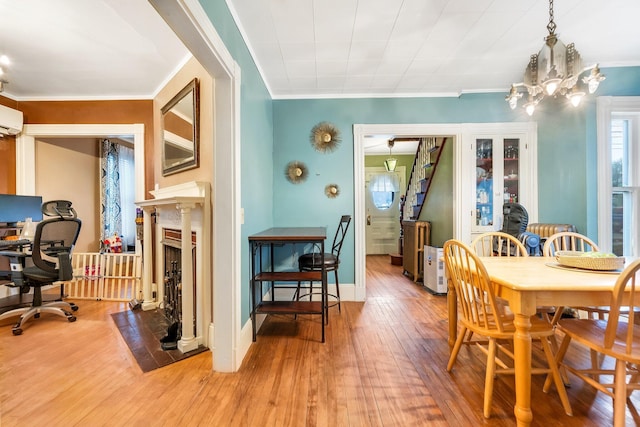 363 Broadway, Bangor, ME 04401 - dining area featuring light wood-style floors, ornamental molding, a fireplace, an AC wall unit, and a chandelier