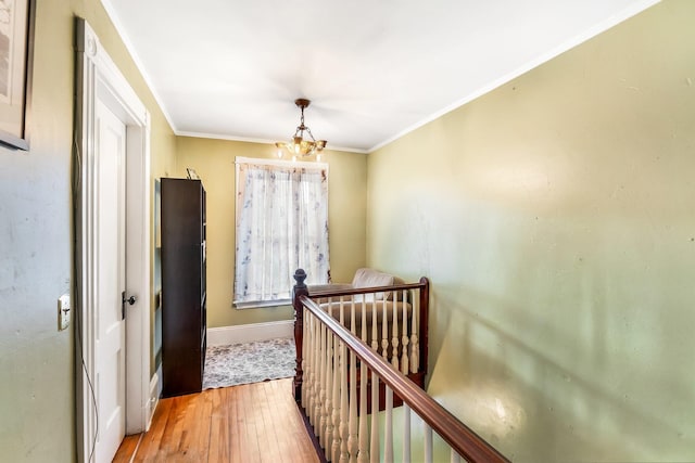 363 Broadway, Bangor, ME 04401 - hallway with an upstairs landing, a chandelier, light wood finished floors, baseboards, and crown molding