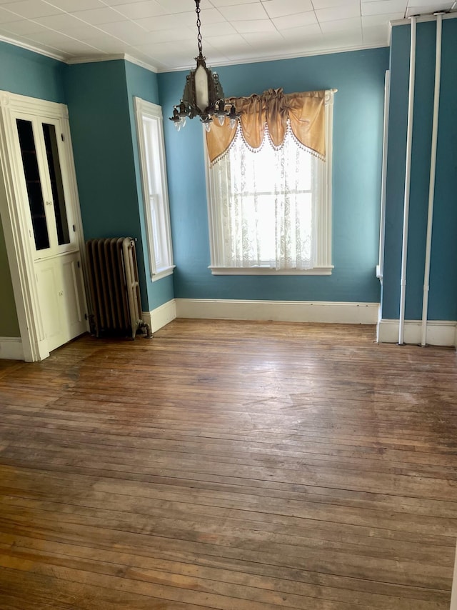 363 Broadway, Bangor, ME 04401 - unfurnished dining area with radiator heating unit, crown molding, wood-type flooring, and baseboards