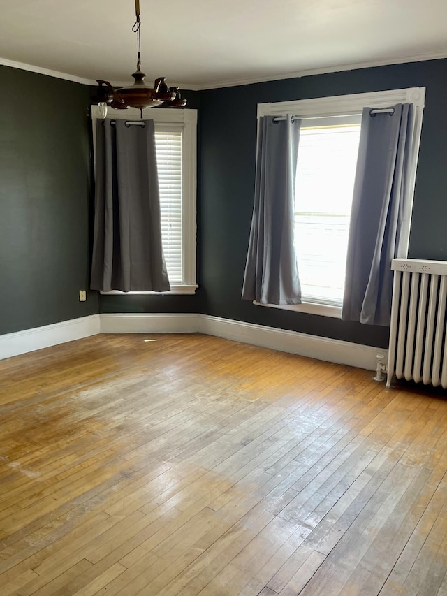 363 Broadway, Bangor, ME 04401 - unfurnished room with radiator heating unit, crown molding, hardwood / wood-style floors, baseboards, and a chandelier