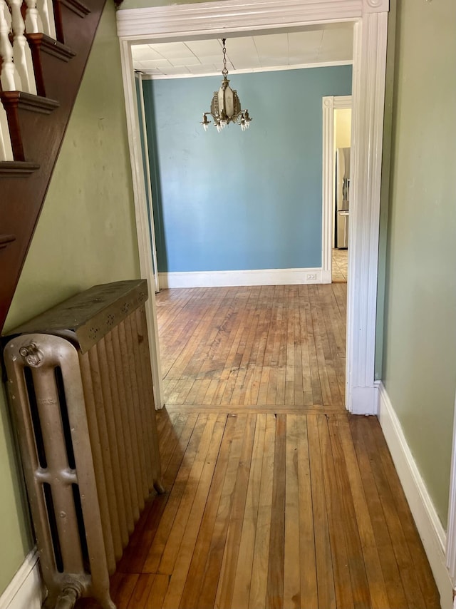 363 Broadway, Bangor, ME 04401 - corridor featuring radiator, a chandelier, hardwood / wood-style flooring, and baseboards