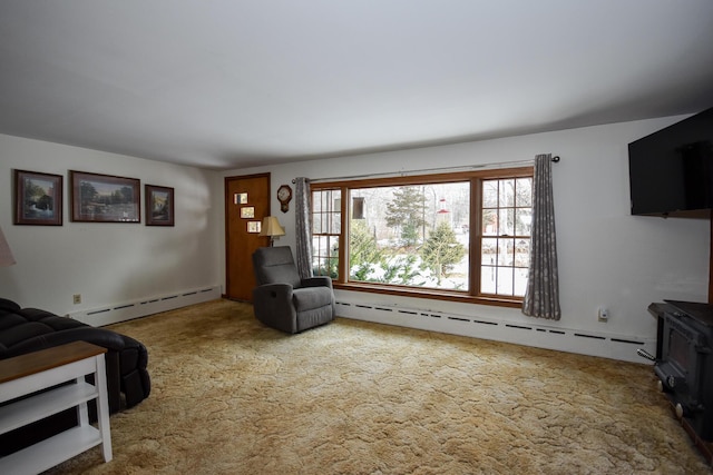 living room with a baseboard radiator, carpet, and a wood stove