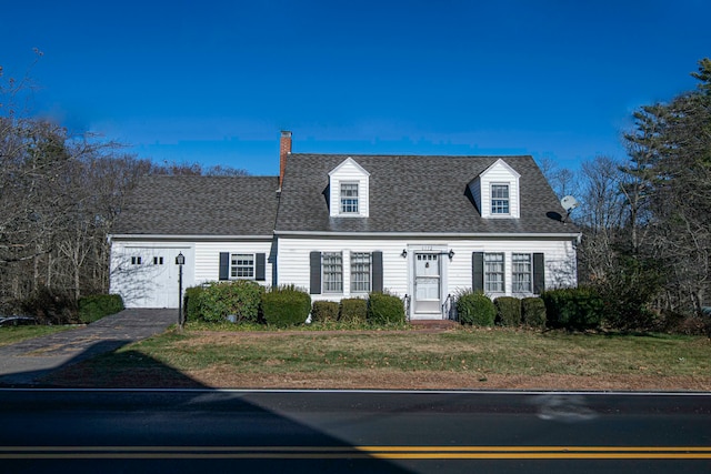 cape cod house with a garage and a front lawn