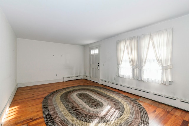 interior space with a baseboard radiator and hardwood / wood-style flooring