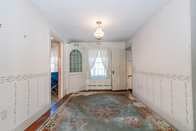 entrance foyer featuring hardwood / wood-style flooring and a baseboard heating unit