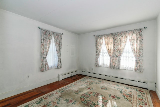 spare room featuring hardwood / wood-style flooring and baseboard heating