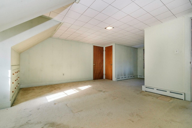 additional living space featuring light carpet, a baseboard radiator, and vaulted ceiling