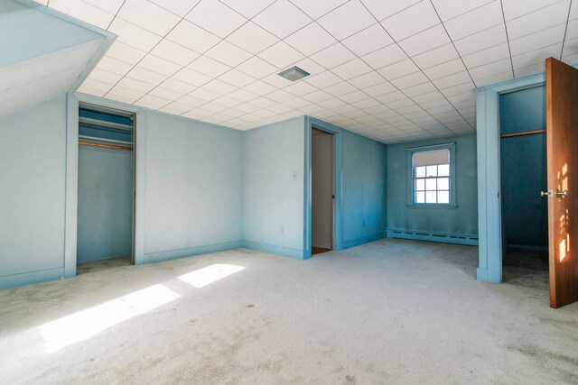 unfurnished bedroom featuring light carpet, a baseboard radiator, and a closet