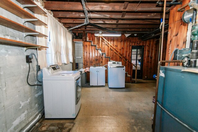 basement featuring wood walls and washing machine and dryer