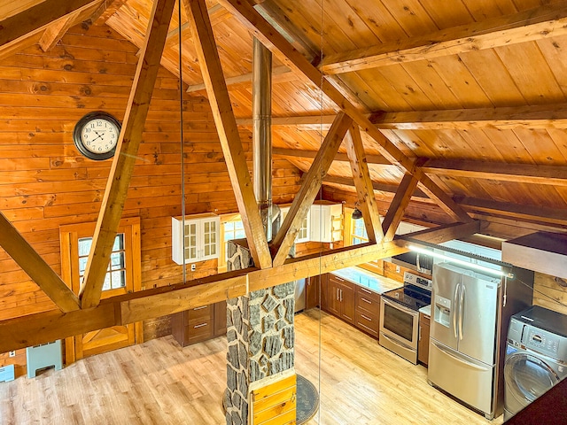 kitchen featuring washer / dryer, appliances with stainless steel finishes, light hardwood / wood-style floors, and wooden walls