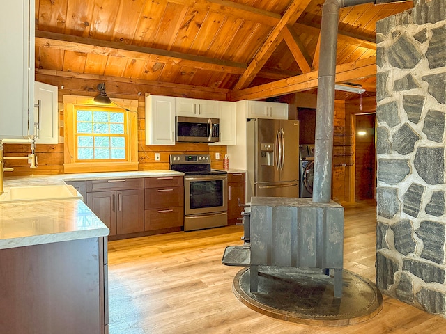 kitchen with white cabinets, light wood-type flooring, and stainless steel appliances