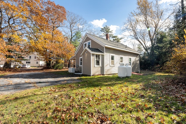 view of side of property with a yard and central air condition unit