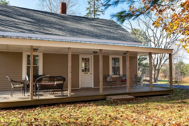 entrance to property with ceiling fan and a deck