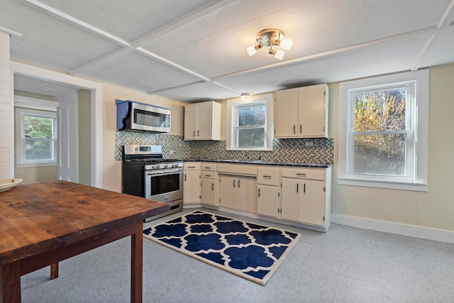 kitchen with cream cabinets, stainless steel appliances, tasteful backsplash, and sink