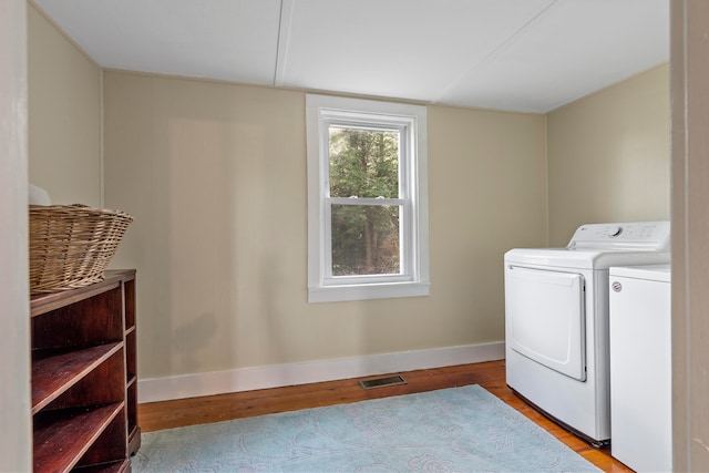 laundry room featuring light hardwood / wood-style flooring and washing machine and clothes dryer