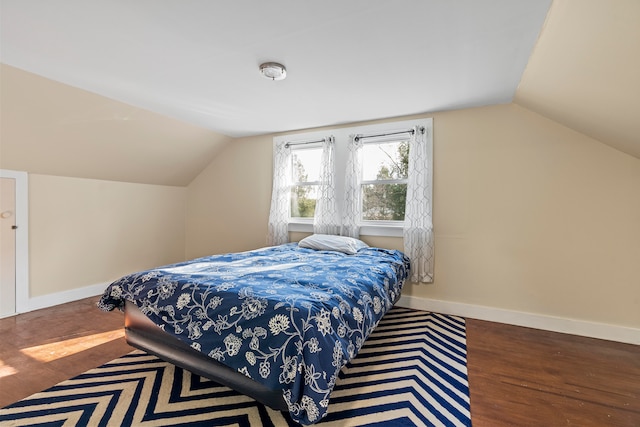 bedroom with wood-type flooring and vaulted ceiling