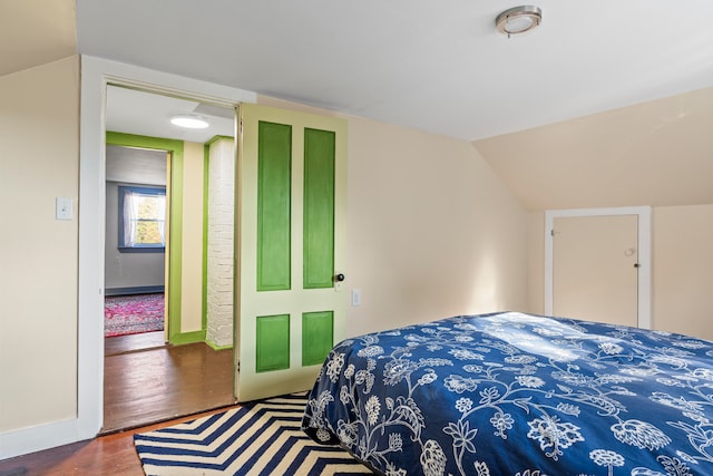 bedroom featuring hardwood / wood-style floors and lofted ceiling