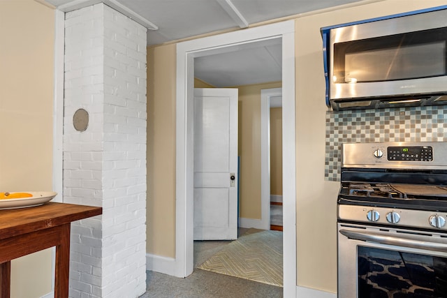 kitchen with decorative columns, decorative backsplash, carpet, and appliances with stainless steel finishes