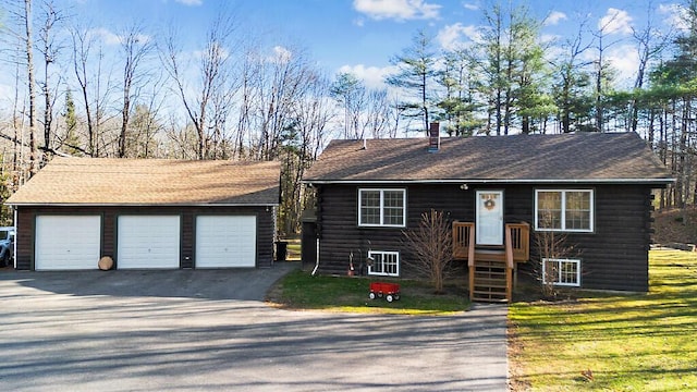 ranch-style home featuring a garage, an outdoor structure, and a front yard