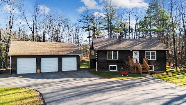 ranch-style home with a garage and an outbuilding