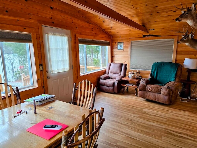 dining space featuring wood ceiling, wooden walls, lofted ceiling with beams, and light wood-type flooring