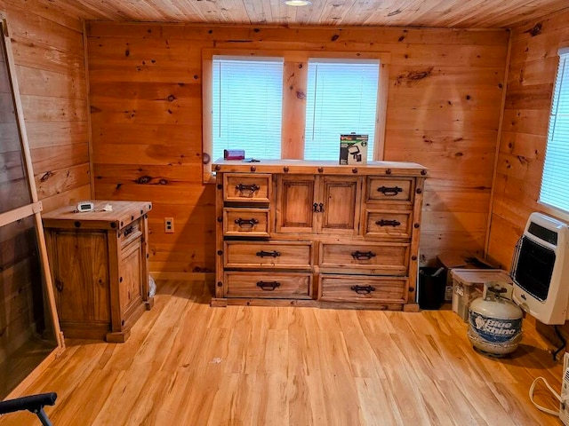 interior space with hardwood / wood-style floors, plenty of natural light, wood walls, and heating unit