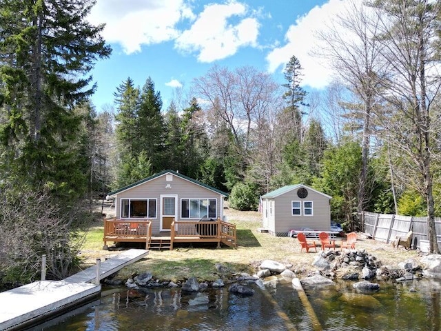 back of house with a deck with water view and an outdoor structure