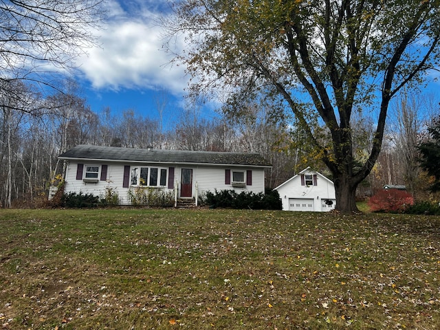 single story home with a garage, an outbuilding, and a front yard