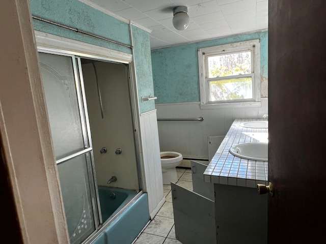 full bathroom with tile patterned flooring, vanity, toilet, and shower / bath combination with glass door