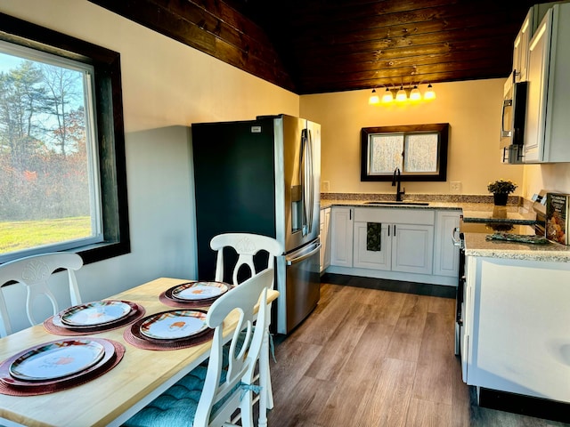 kitchen featuring lofted ceiling, wooden ceiling, sink, light hardwood / wood-style flooring, and stainless steel appliances