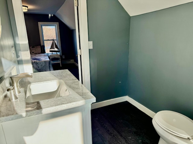 bathroom featuring hardwood / wood-style flooring, vanity, vaulted ceiling, and toilet