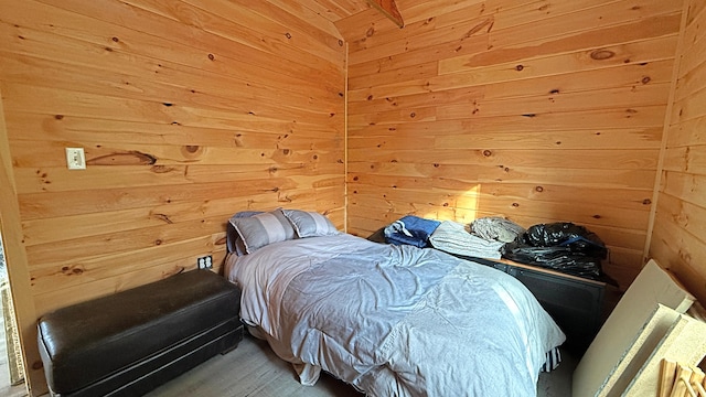 bedroom with wood-type flooring and wooden walls