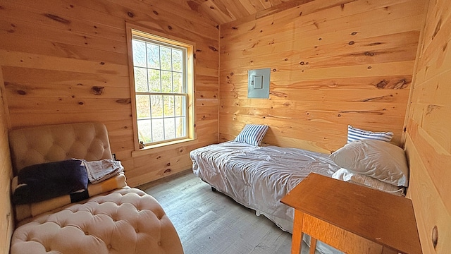 bedroom with wooden walls and hardwood / wood-style flooring