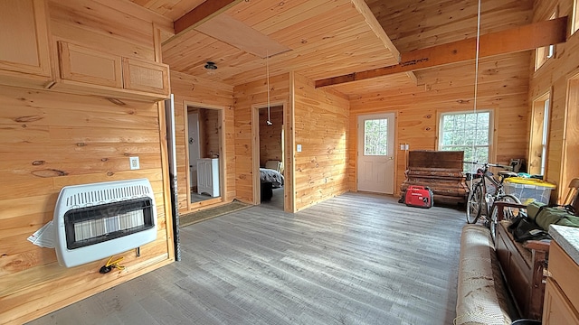 interior space with beamed ceiling, dark hardwood / wood-style floors, wooden walls, and heating unit