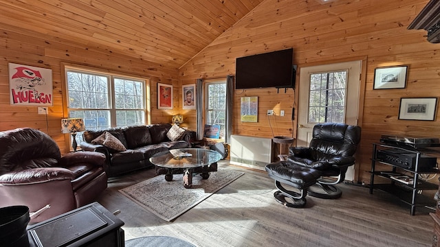 living room featuring hardwood / wood-style floors, wooden walls, wood ceiling, and high vaulted ceiling