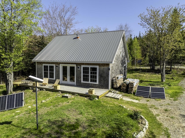 10 Bog Brook Way, Cutler, ME 04626 - back of house with ground mounted solar panels, french doors, metal roof, and a wooden deck