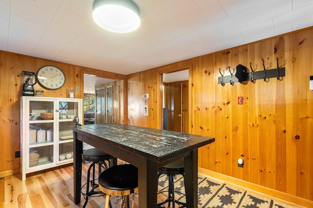 dining room featuring wood walls and wood-type flooring