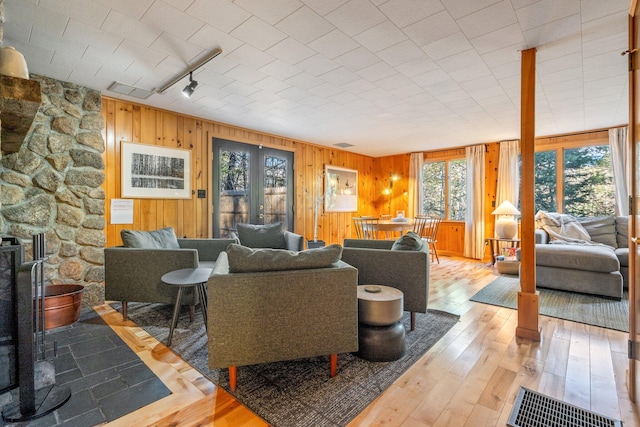 living room featuring hardwood / wood-style flooring, a wood stove, and wood walls