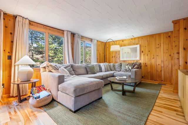 living room with hardwood / wood-style flooring and wooden walls