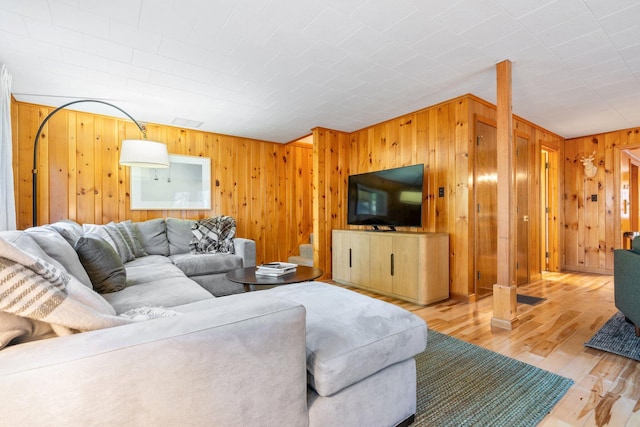 living room featuring wooden walls and light hardwood / wood-style floors