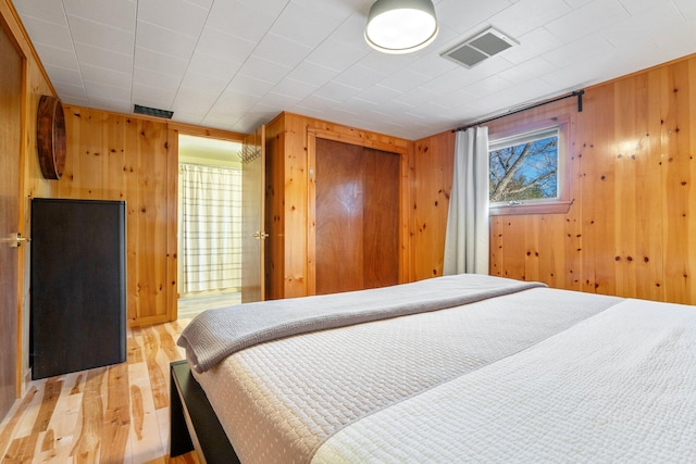 bedroom with wood-type flooring and wooden walls