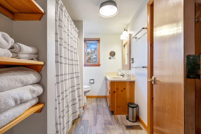 bathroom featuring vanity, toilet, and wood-type flooring