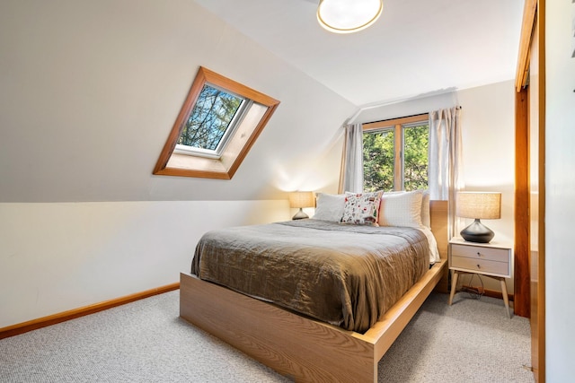 carpeted bedroom with lofted ceiling with skylight