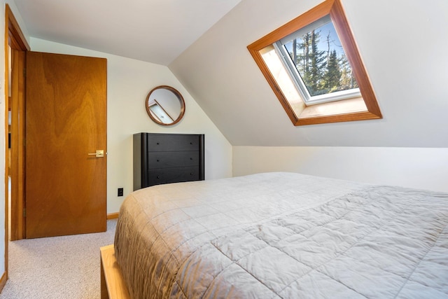 bedroom with lofted ceiling with skylight and light colored carpet