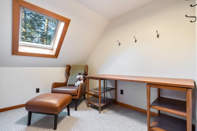 sitting room with lofted ceiling with skylight and light colored carpet