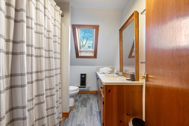 bathroom featuring hardwood / wood-style floors, vanity, toilet, and a skylight