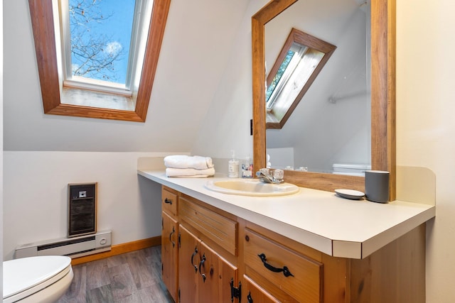 bathroom with hardwood / wood-style floors, vanity, toilet, and a baseboard heating unit