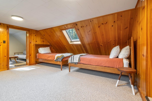 bedroom featuring carpet floors, a skylight, and wood walls