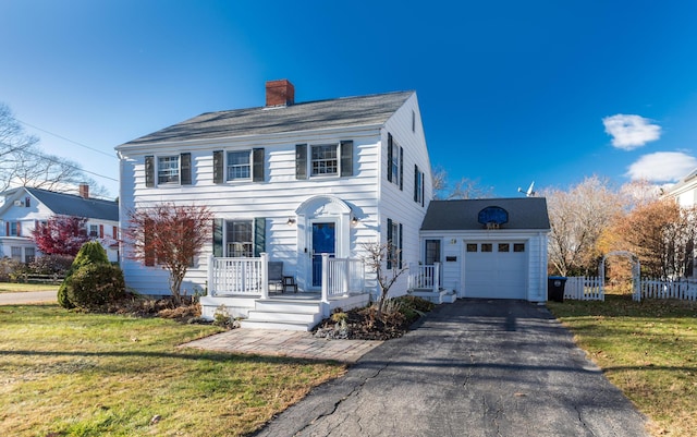 colonial inspired home with a garage and a front yard