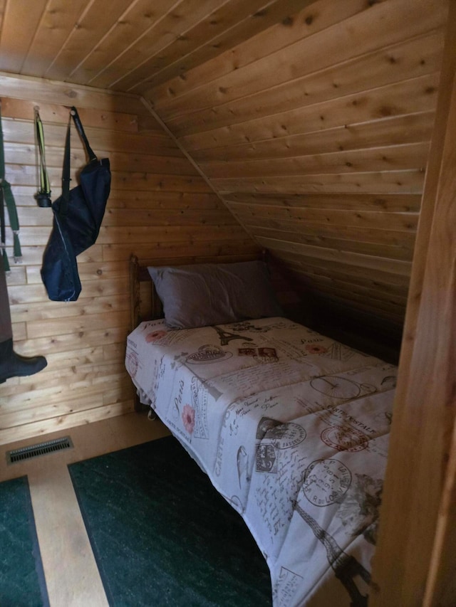 bedroom featuring lofted ceiling, wooden walls, and wooden ceiling